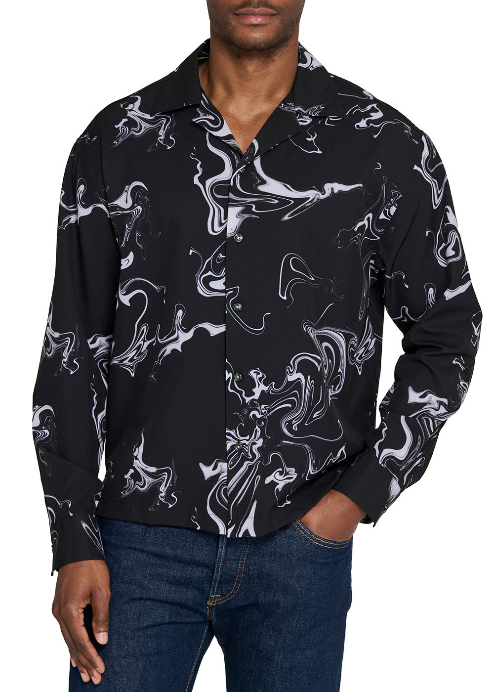 Man wearing a black shirt with white abstract patterns on a white background